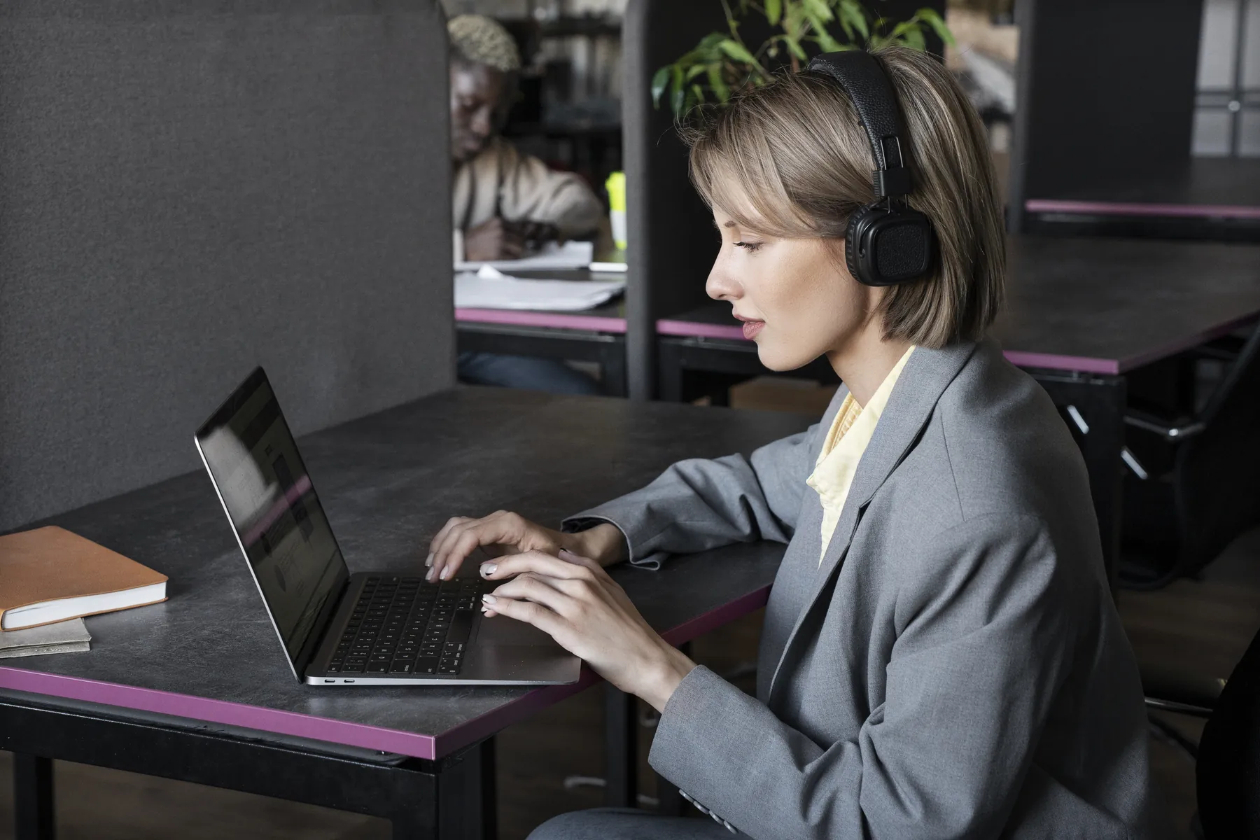 Säljare med hörlurar som arbetar vid sin laptop
