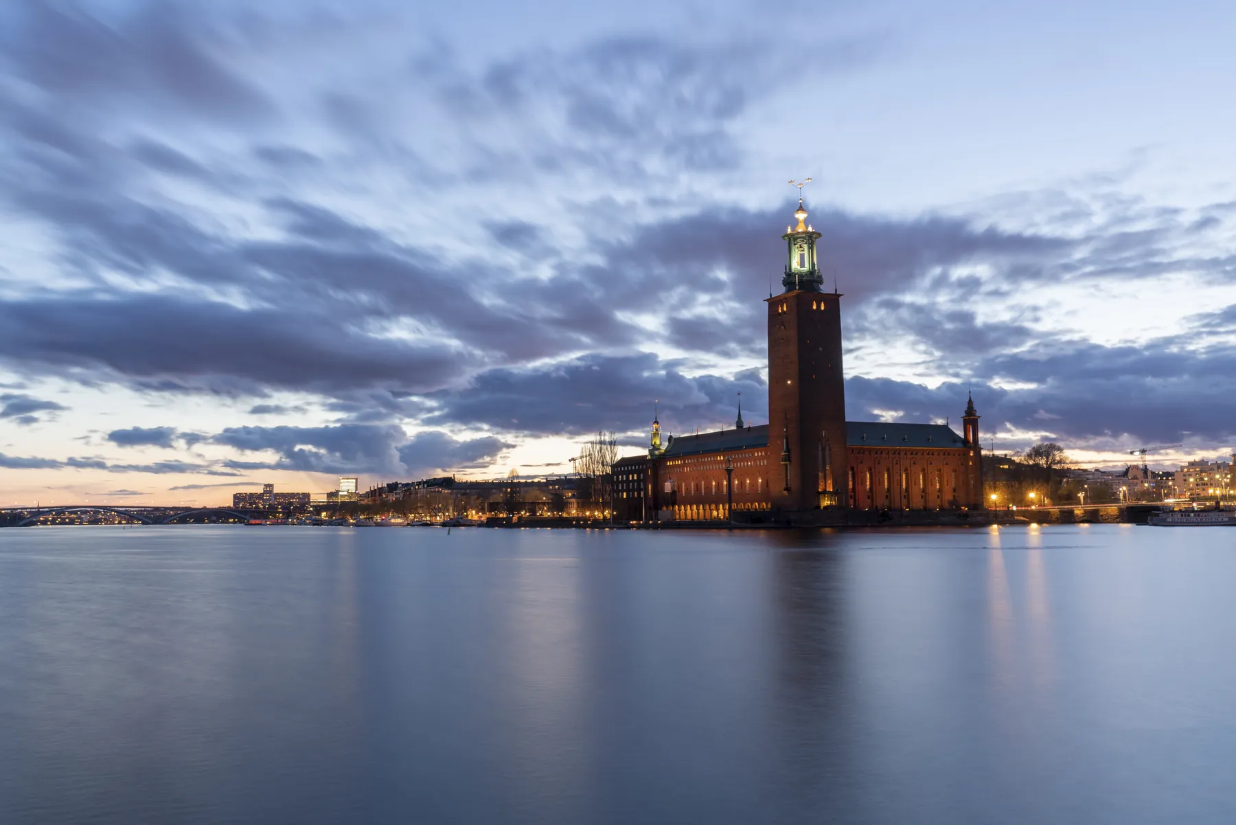 Stockholms stadshus i skymning sett över vattnet